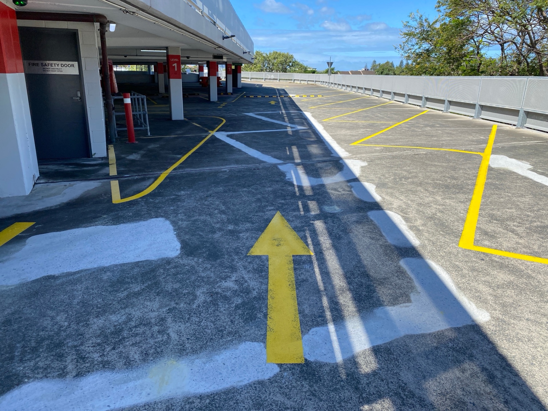 Car park deck with line removal patches and fresh yellow bay markings at Pacific Fair