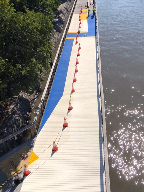 Aerial view of Brisbane riverside boardwalk with blue and yellow bikeway line marking