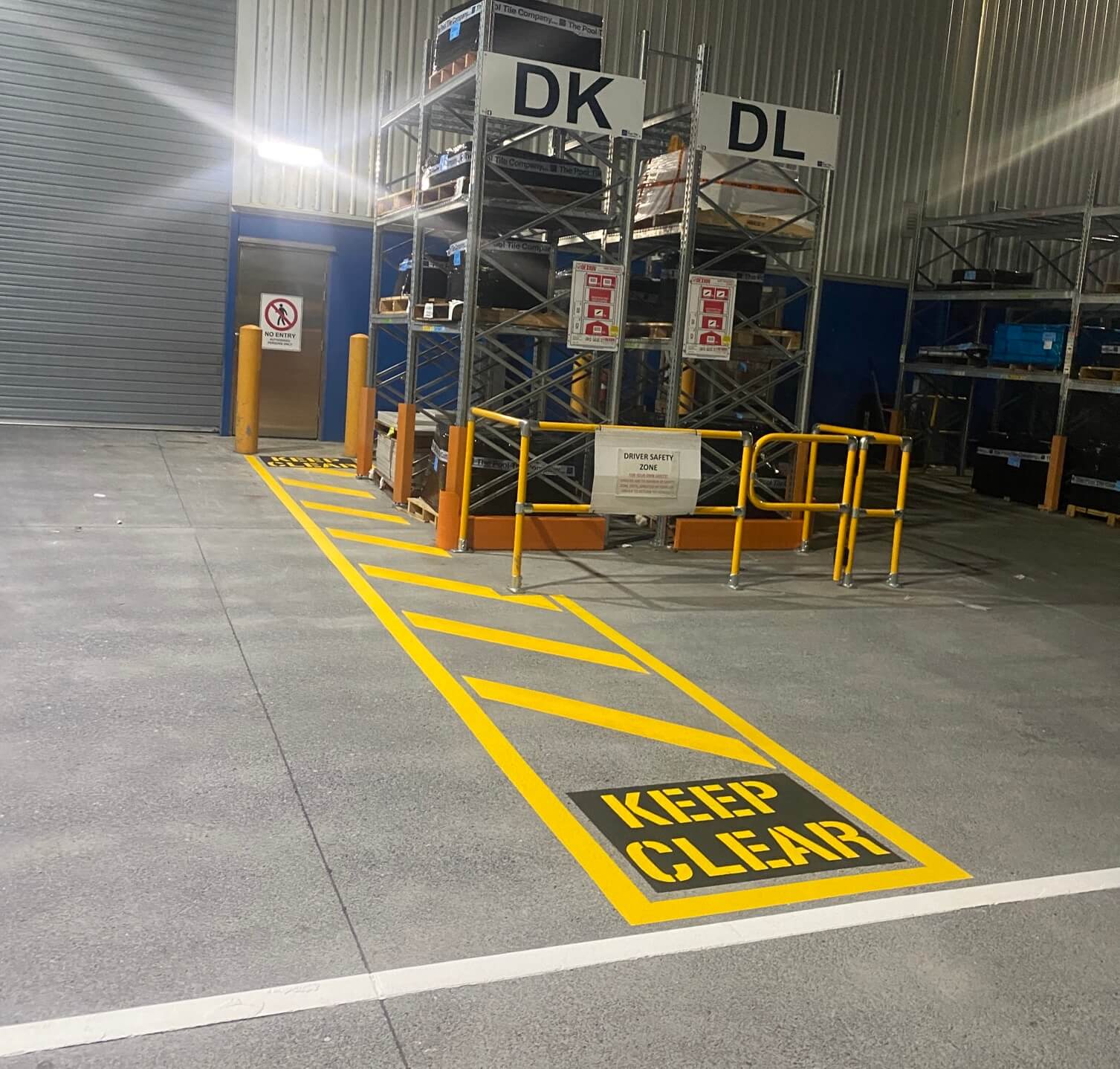 Warehouse yellow Keep Clear stencil and driver safety zone line marking