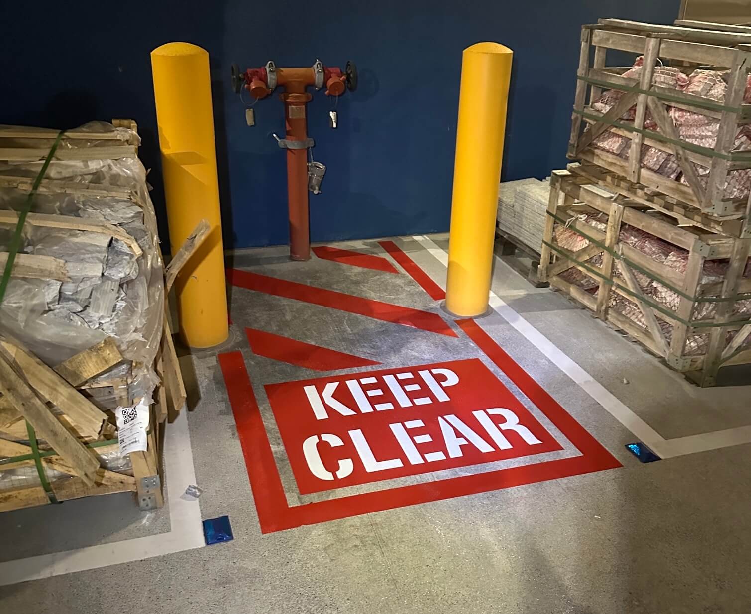 Warehouse red Keep Clear stencil and hazard line marking around fire hydrant