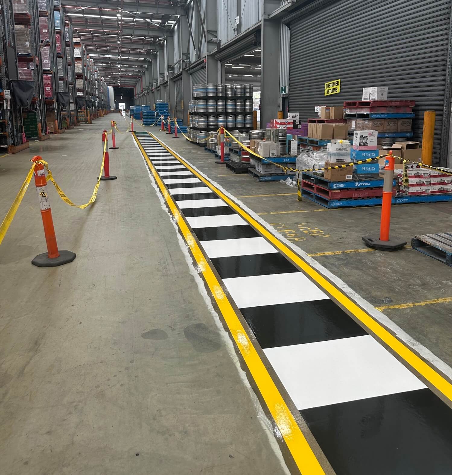 Warehouse black and white pedestrian crossing with yellow safety borders