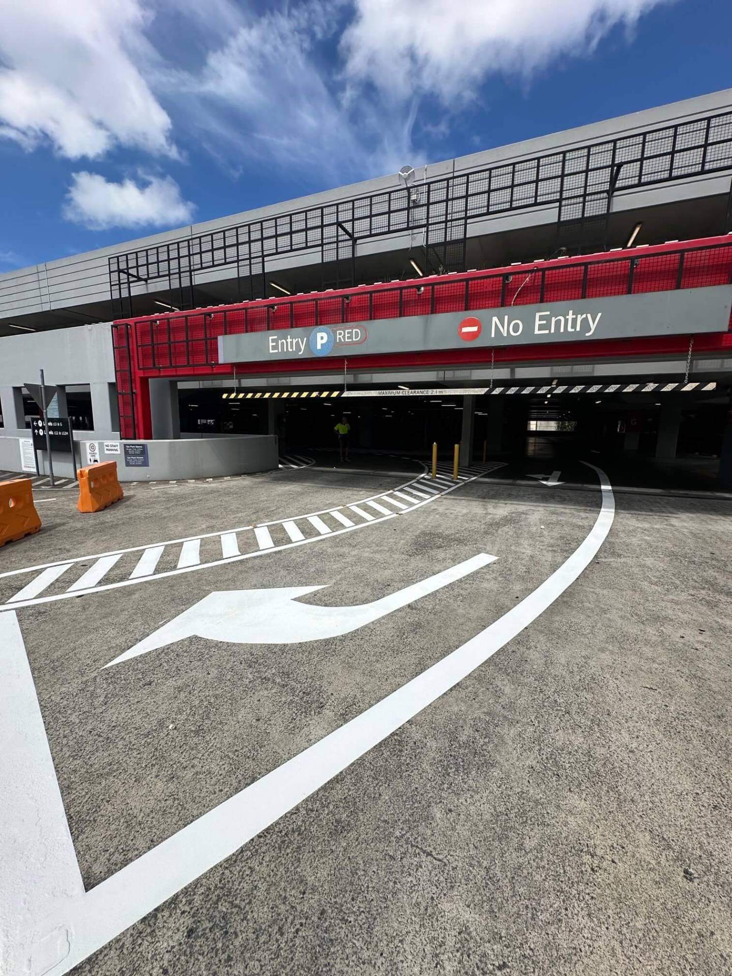 Commercial car park entry with large white directional arrow and edge line marking