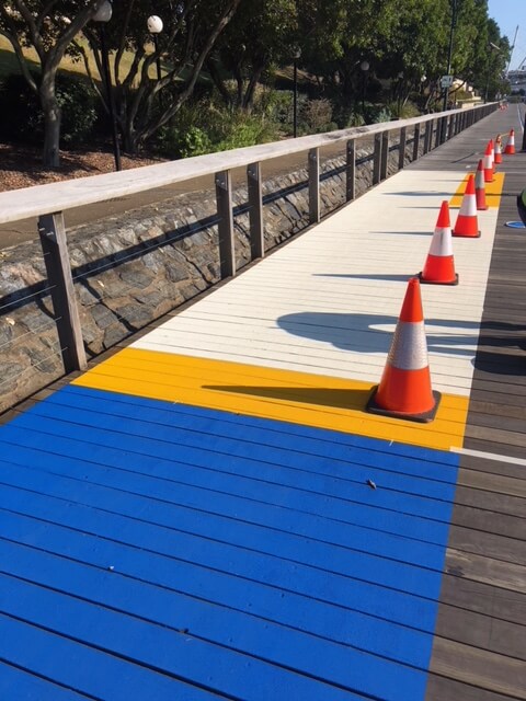 Brisbane riverside boardwalk with blue and yellow bikeway line marking