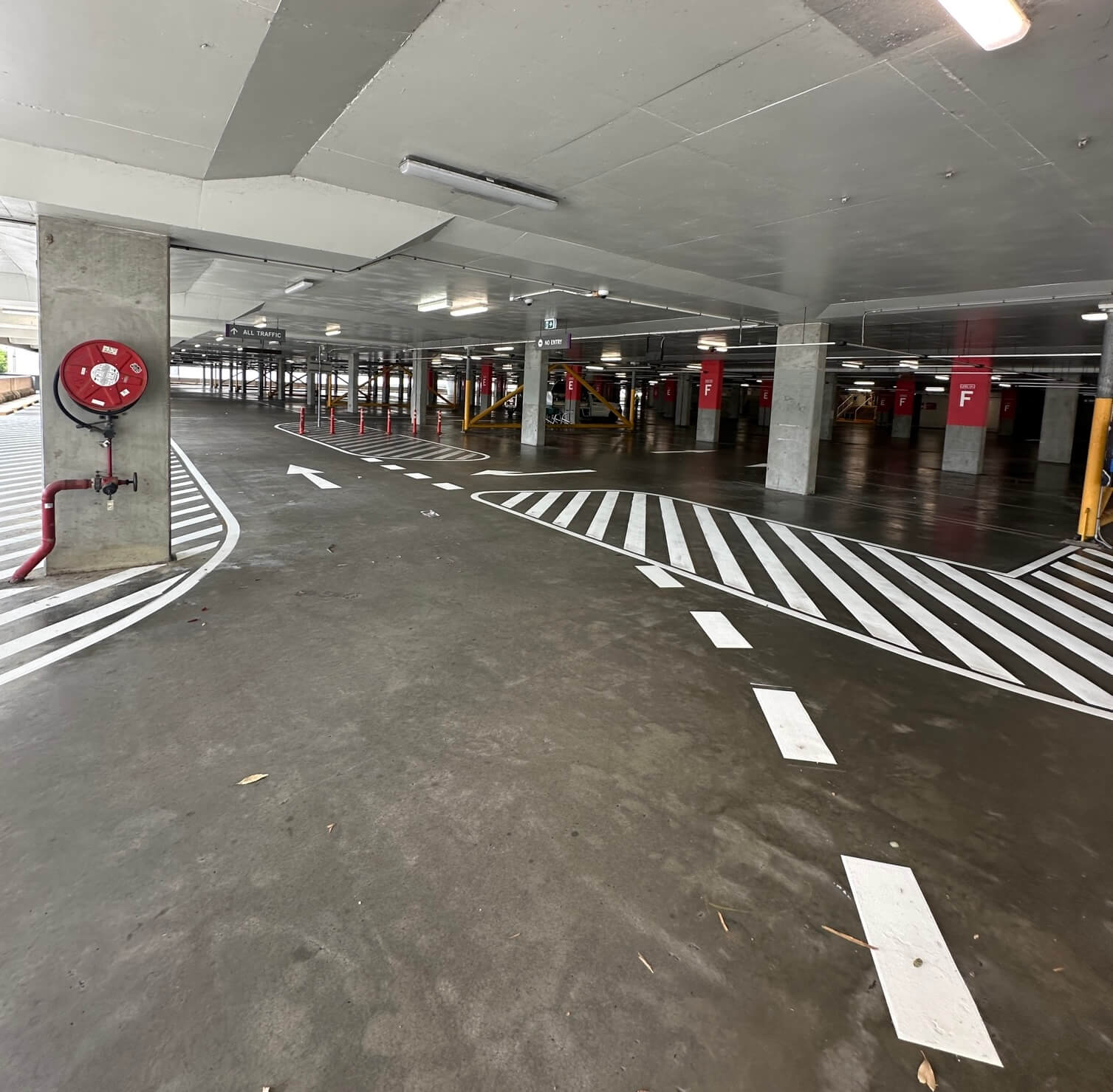 Multi-storey car park with zebra pedestrian crossing and directional arrows