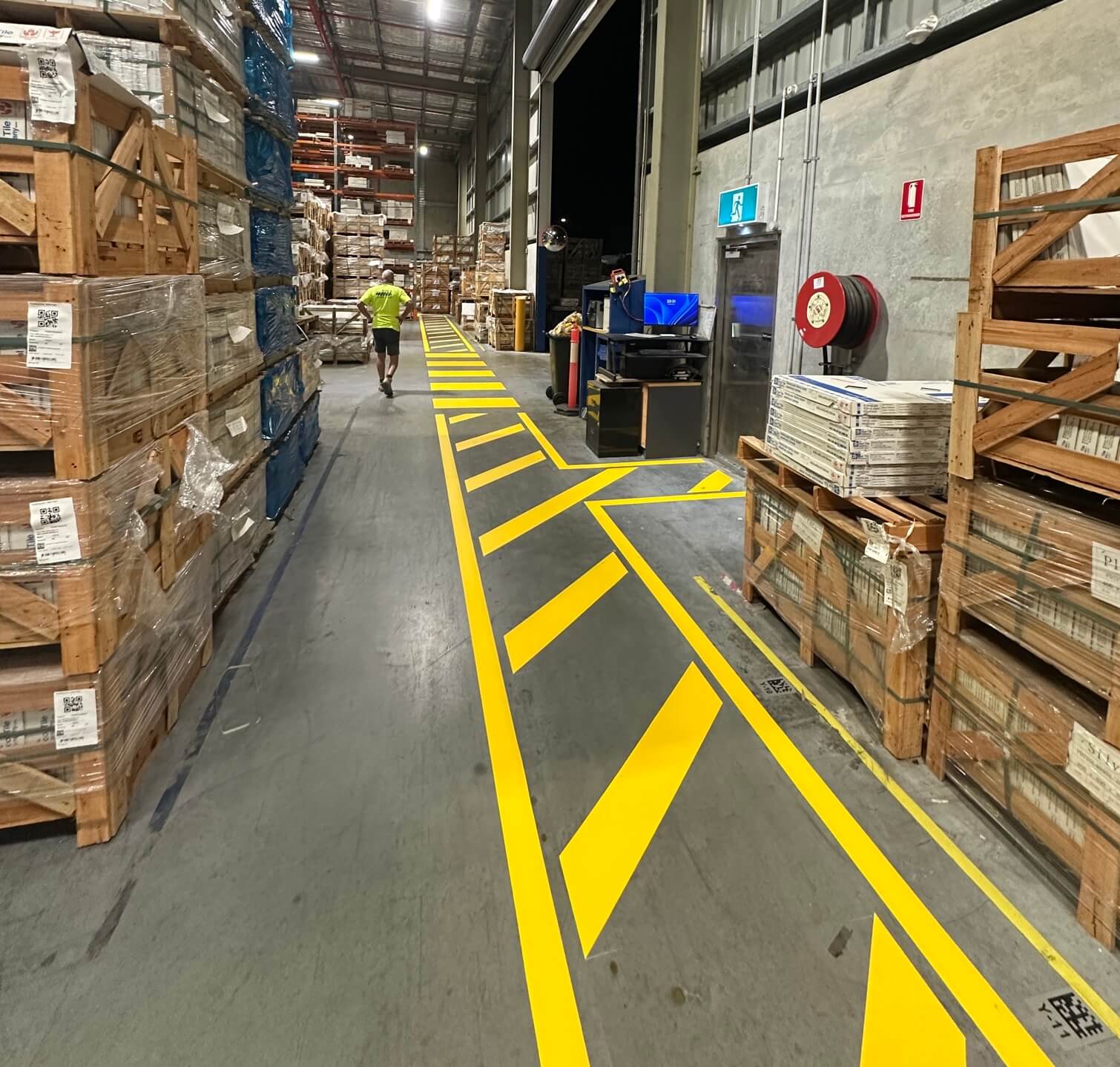 Warehouse yellow chevron safety walkway line marking between pallet racks