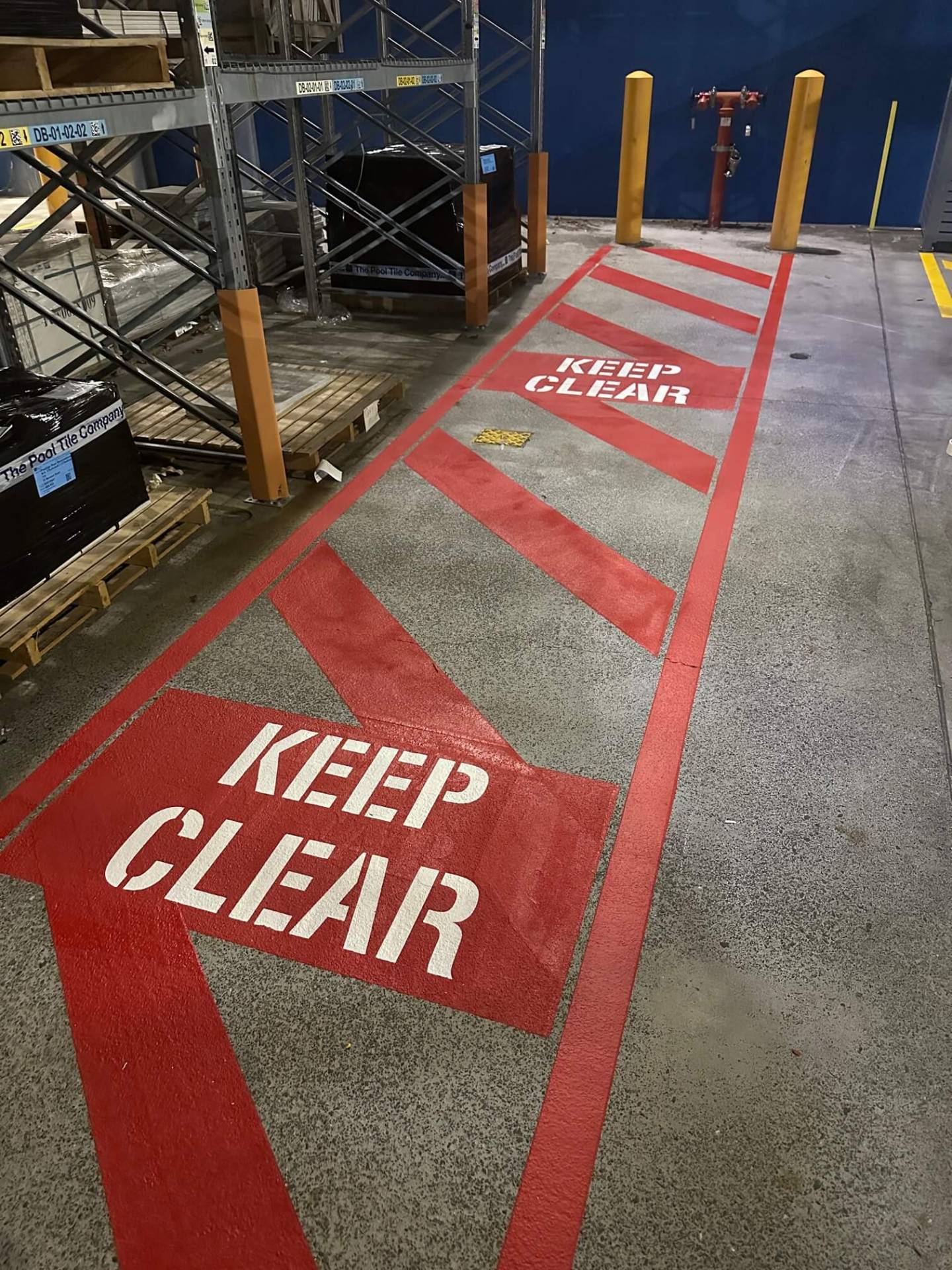 Warehouse red Keep Clear arrow line marking leading to a fire hydrant