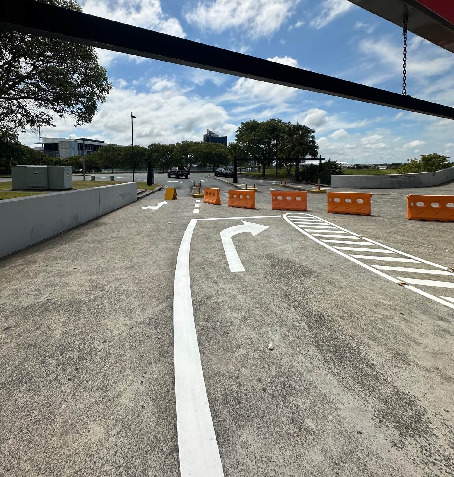 Commercial car park driveway with white directional arrow and hatched traffic island