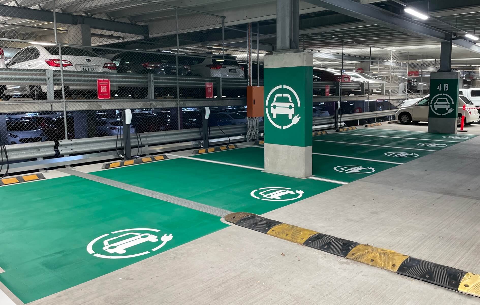 Green EV charging bays and column stencils in a hospital multi-storey car park