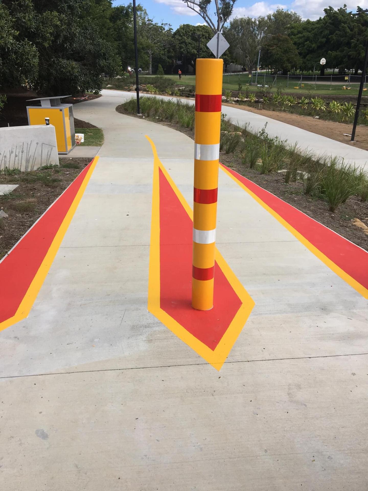 Brisbane bikeway with red and yellow safety line marking around a bollard