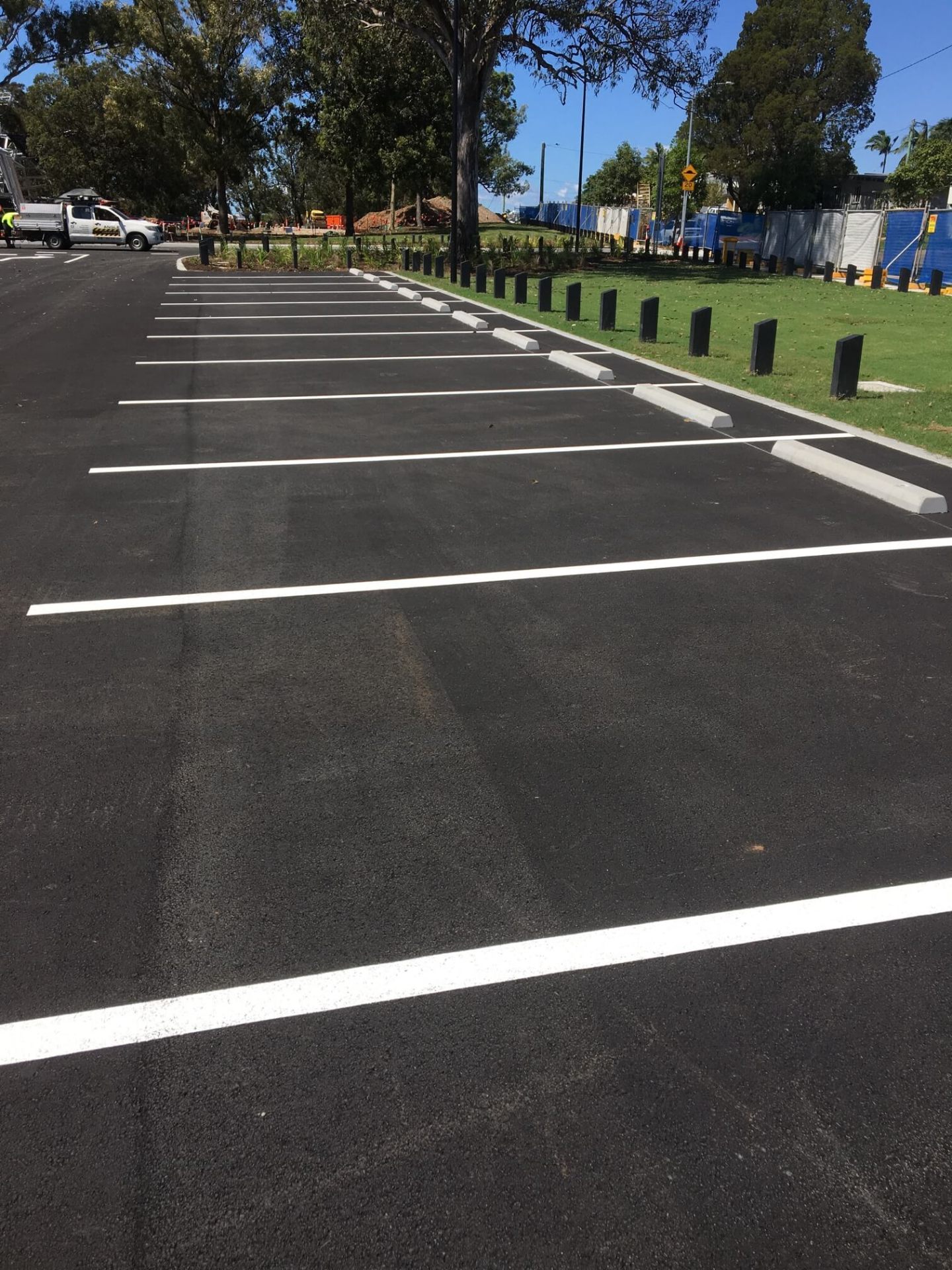 Newly line marked car park bays with white lines and concrete wheel stops