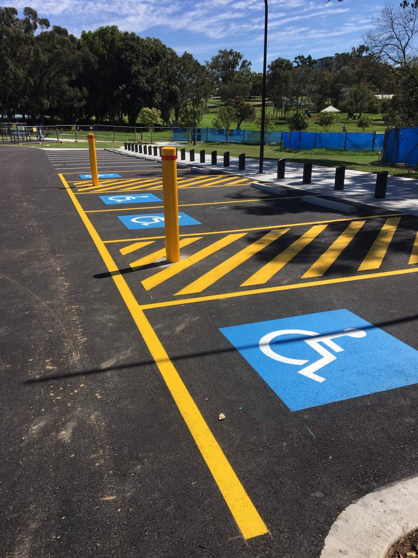 Disabled parking bays with blue wheelchair logos, yellow hatching and bollards