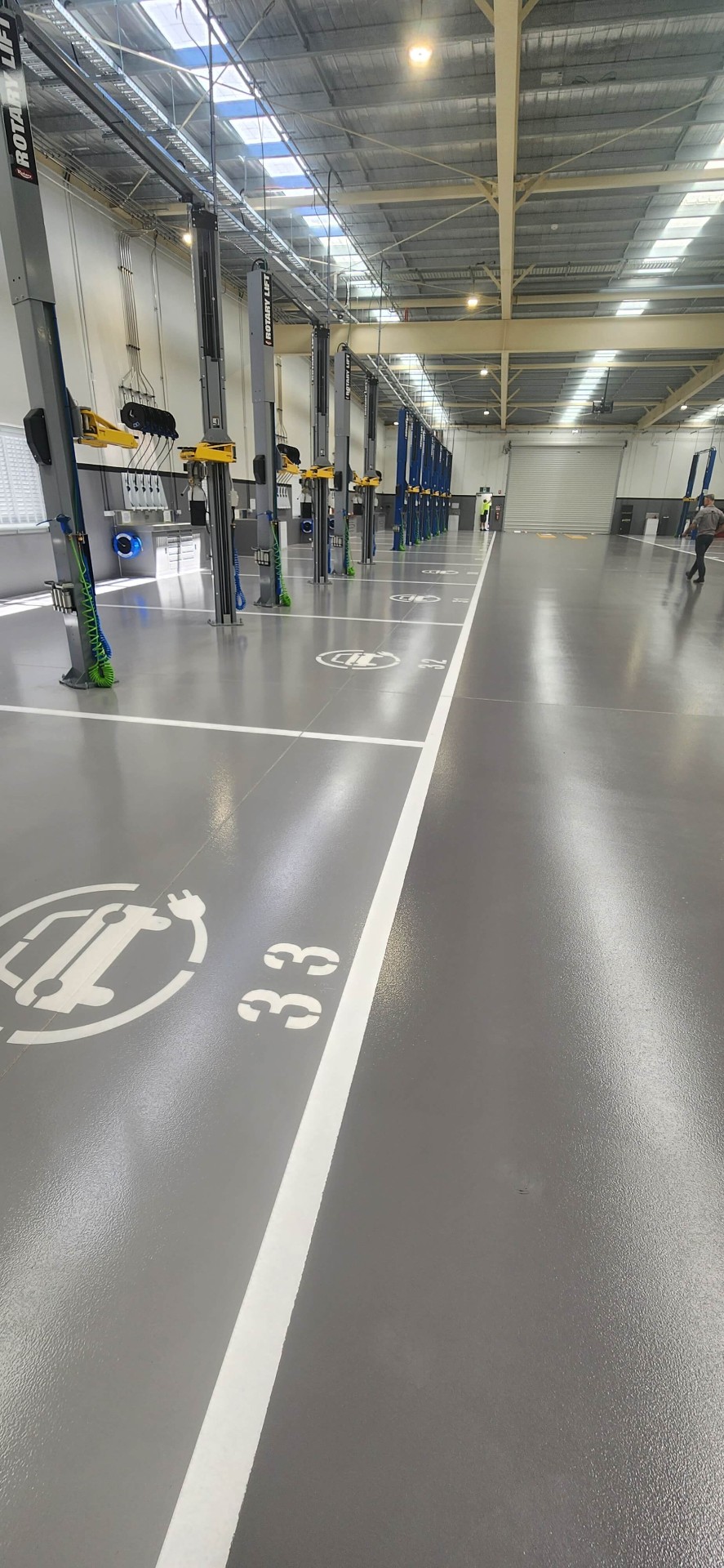 Automotive workshop with EV charging bay line marking and stencilled numbering