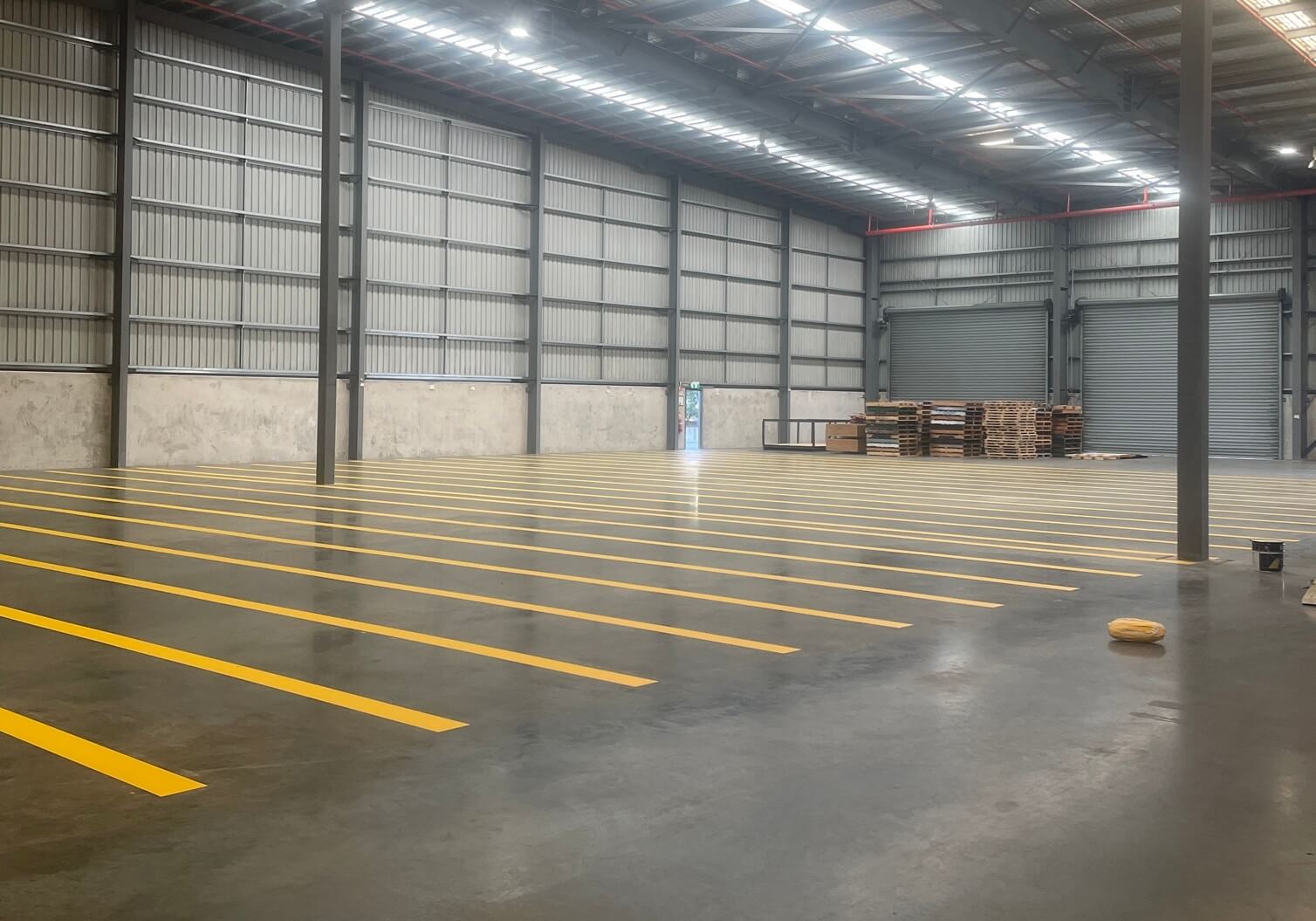Wide warehouse floor with fresh yellow pallet bay line marking
