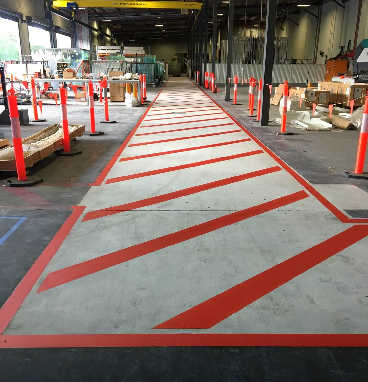Factory walkway with red hatched forklift exclusion line marking
