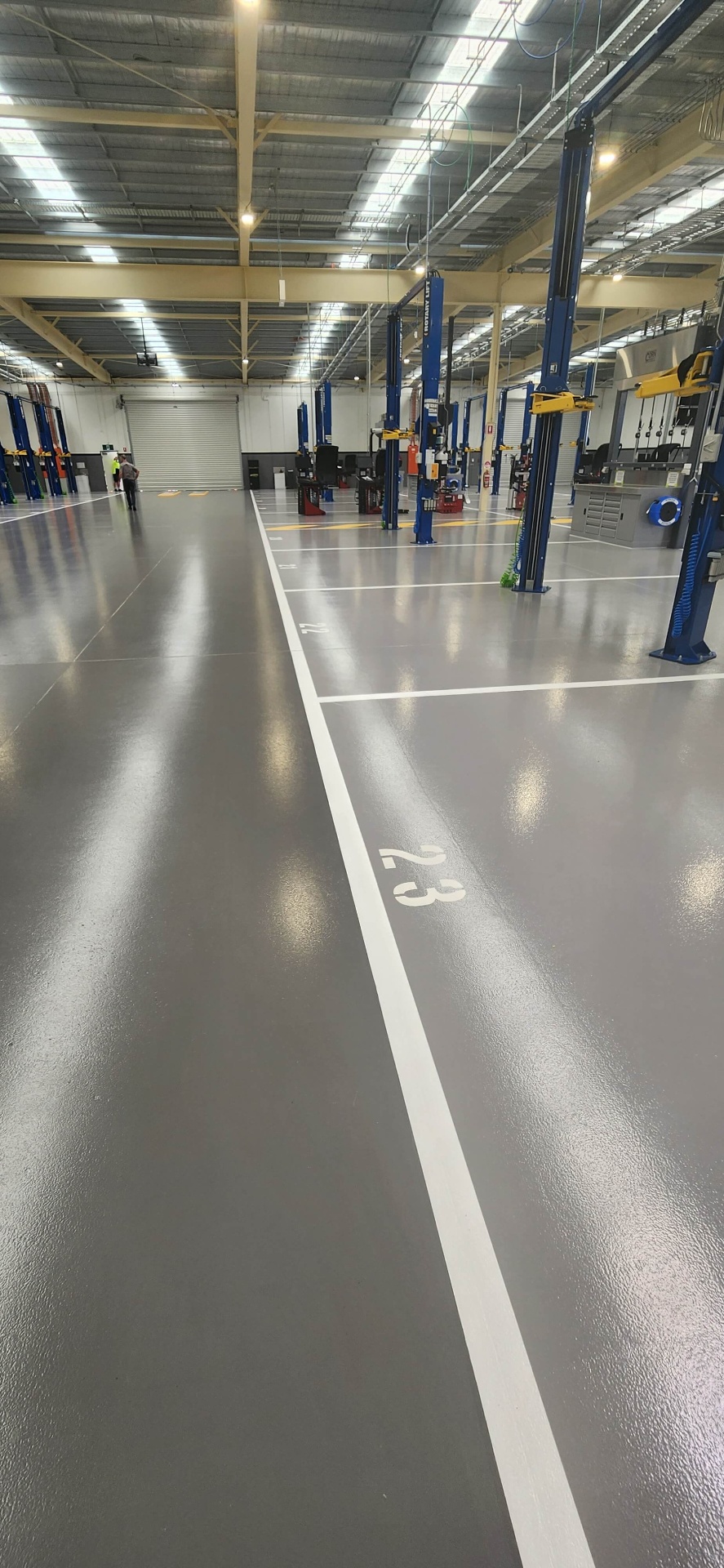 Automotive workshop with numbered service bays and white line marking