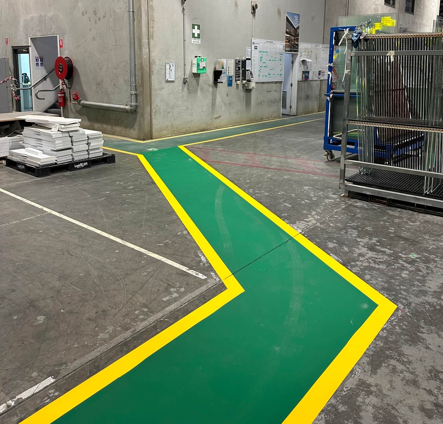 Factory pedestrian walkway marked in green with yellow borders