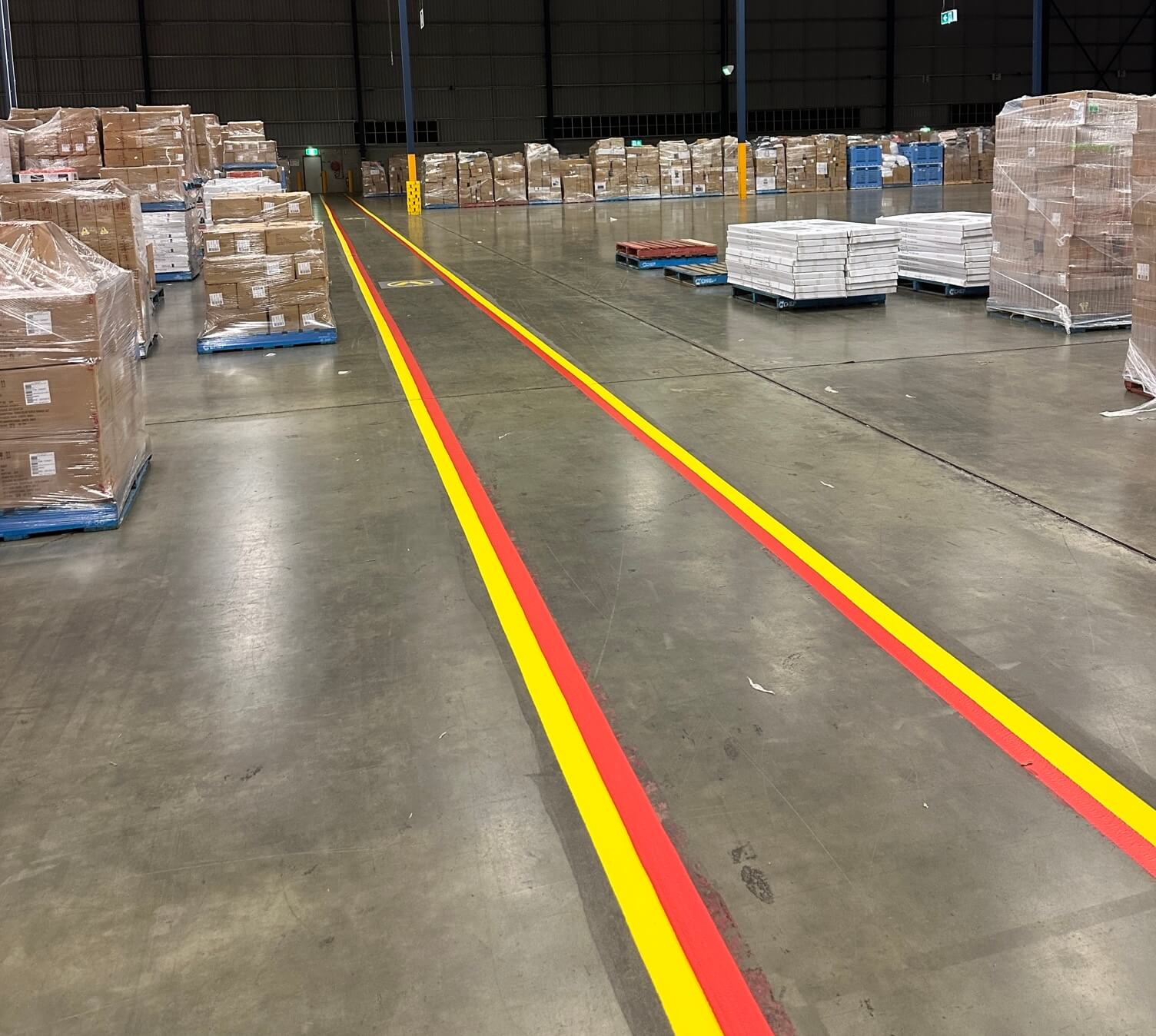 Warehouse yellow and red forklift travel lanes between pallet stock