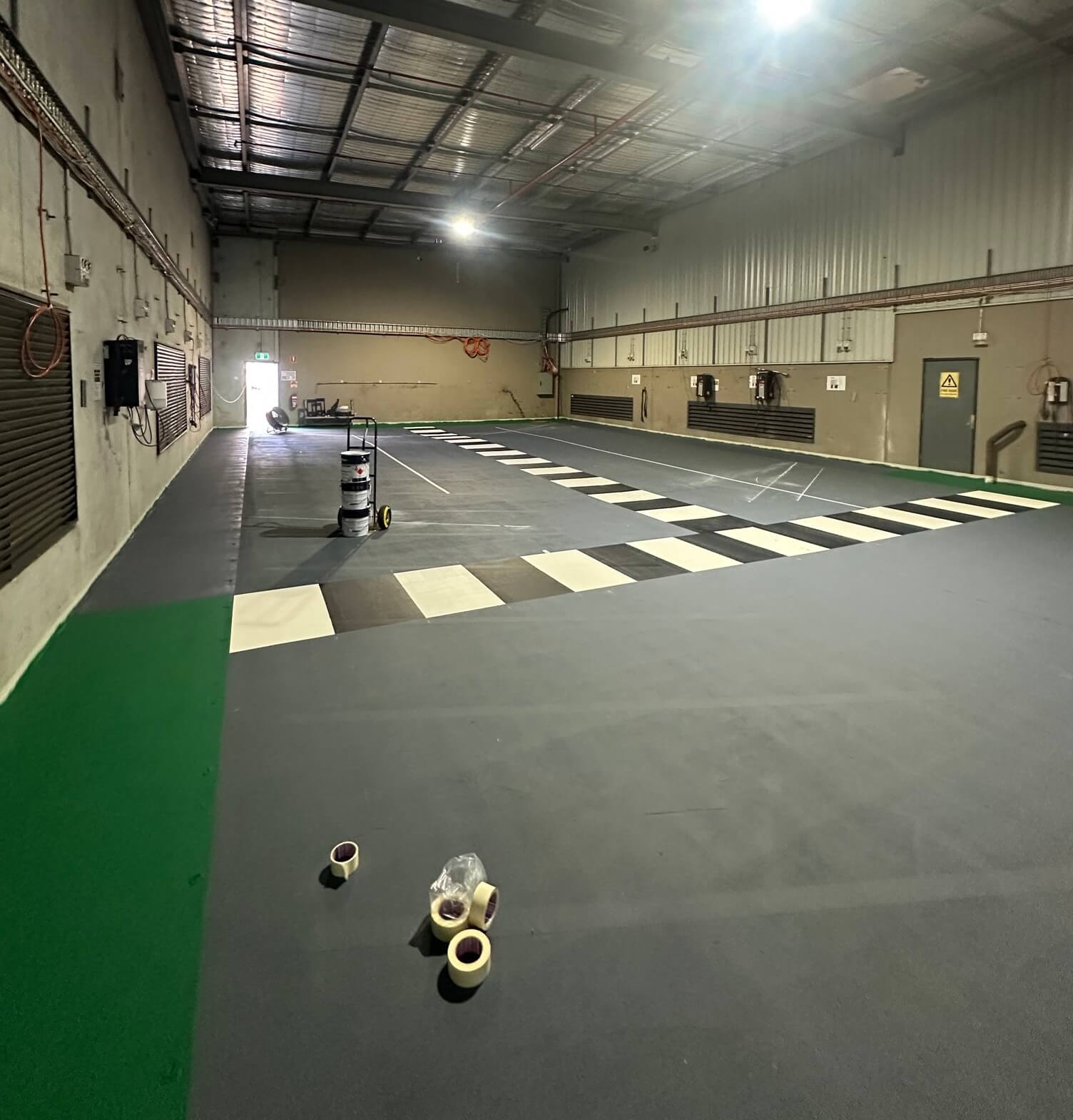 Warehouse grey floor with black and white checkered forklift crossing line marking