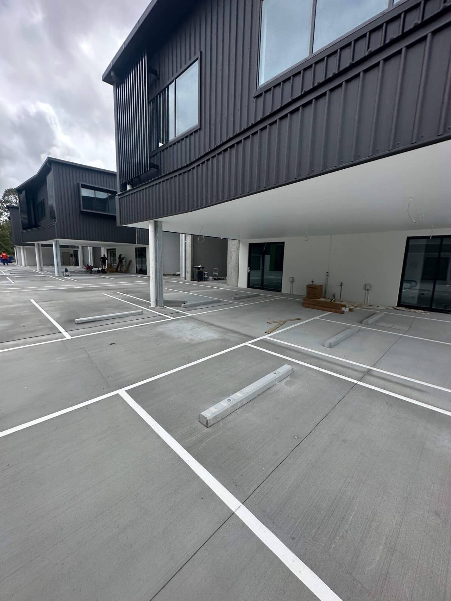 Commercial car park with fresh white line marked bays and concrete wheel stops