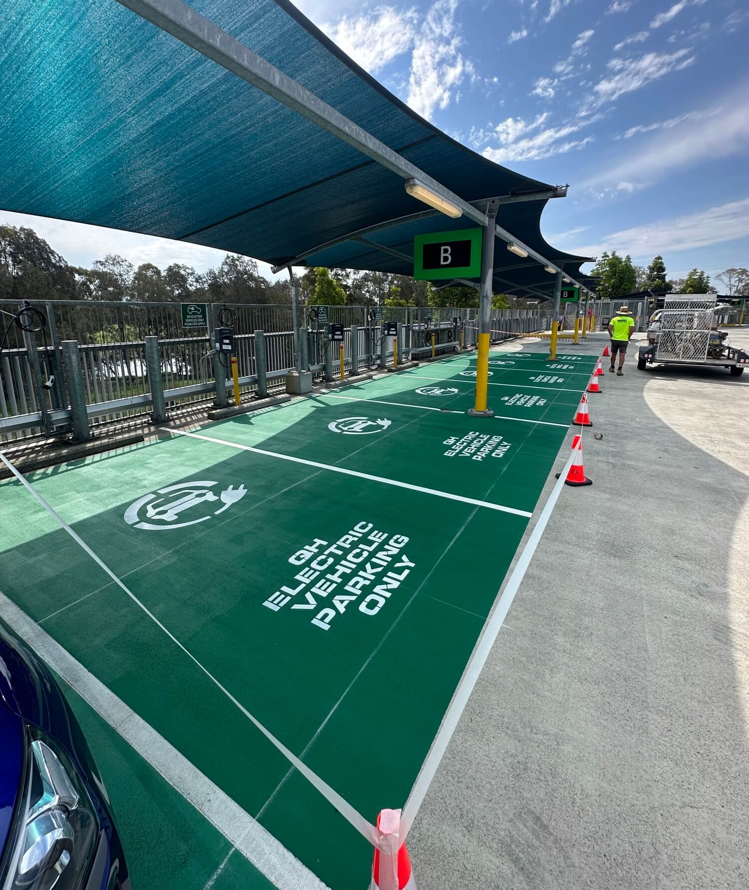 Commercial EV charging bays with green line marking and stencilled EV symbols
