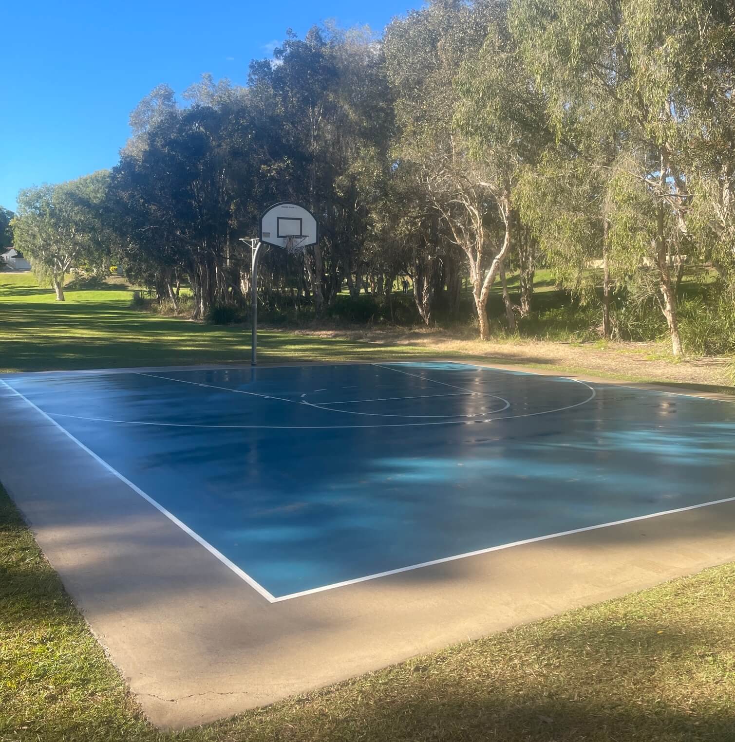 Park basketball court resurfaced in blue with fresh white line marking