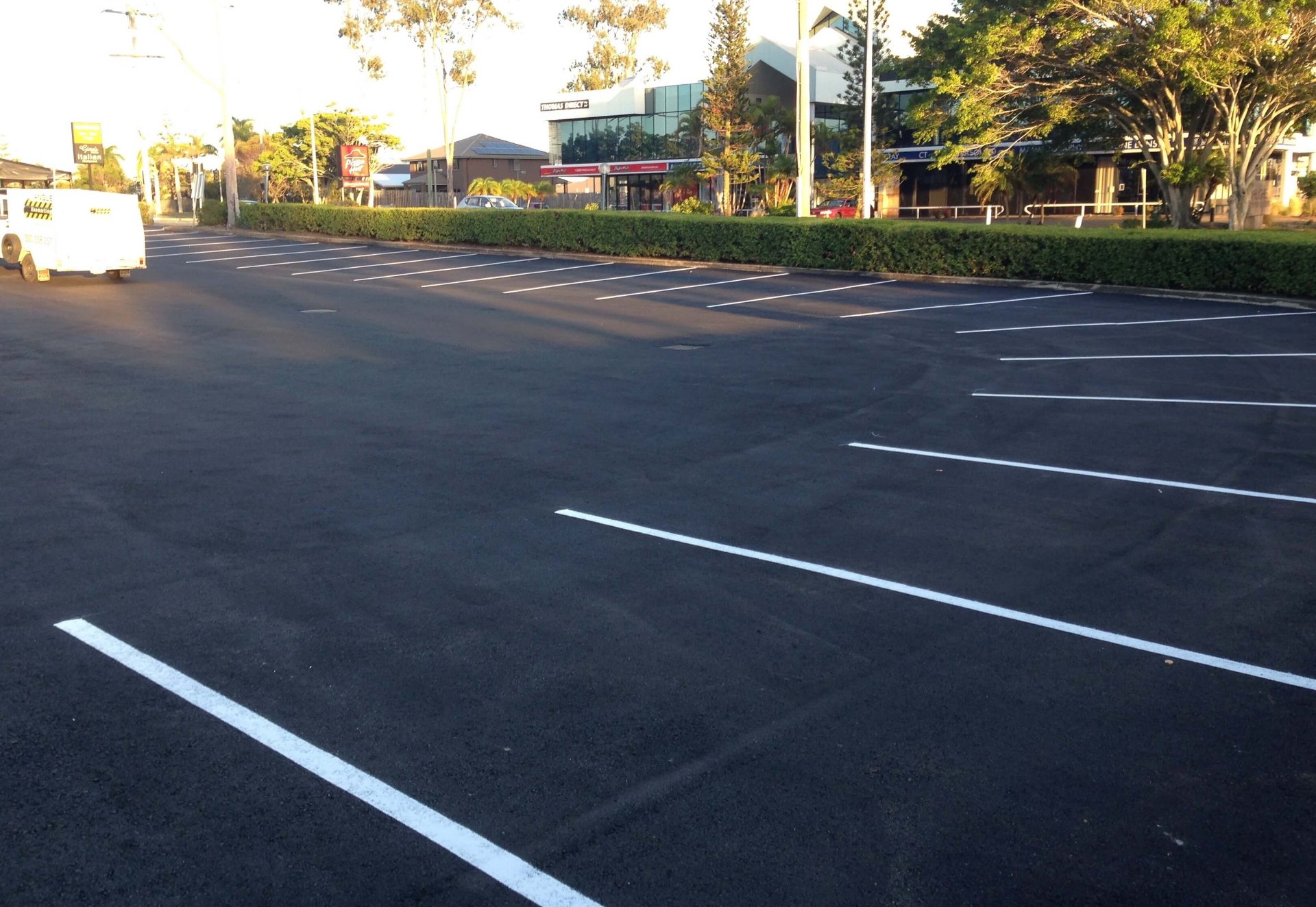 Commercial asphalt car park with fresh white line marked parking bays