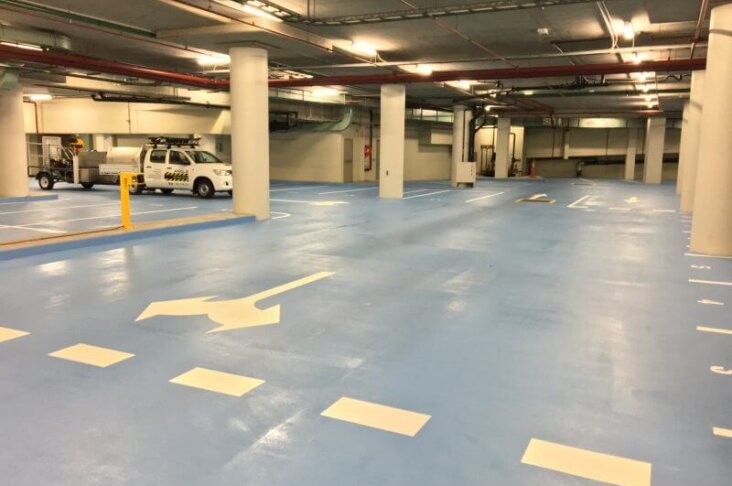 Underground car park with clearly marked parking bays, directional arrows,vensuring safe traffic flow and organised parking