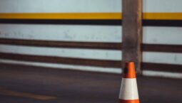 Orange road cone used for traffic control and safety during road line marking projects