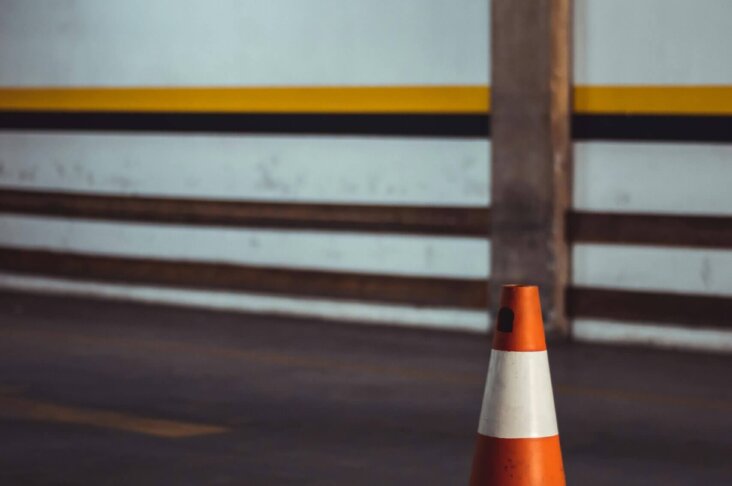 Orange road cone used for traffic control and safety during road line marking projects